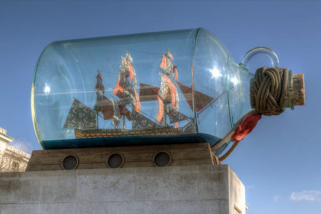 Three-mast ship in a bottle on an outside plinth.