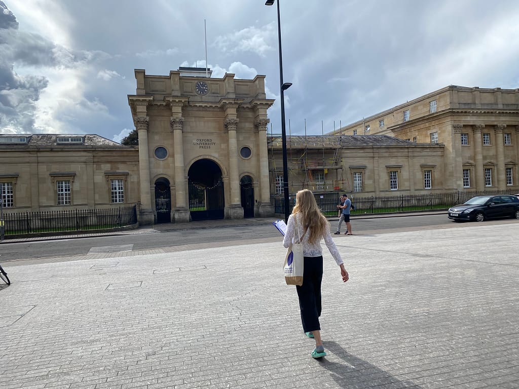 An Uncomfortable Oxford guide walks toward the Oxford Universtiy Press building.