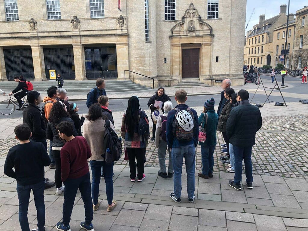An Uncomfortable Oxford guide explaining to a group of attendees.