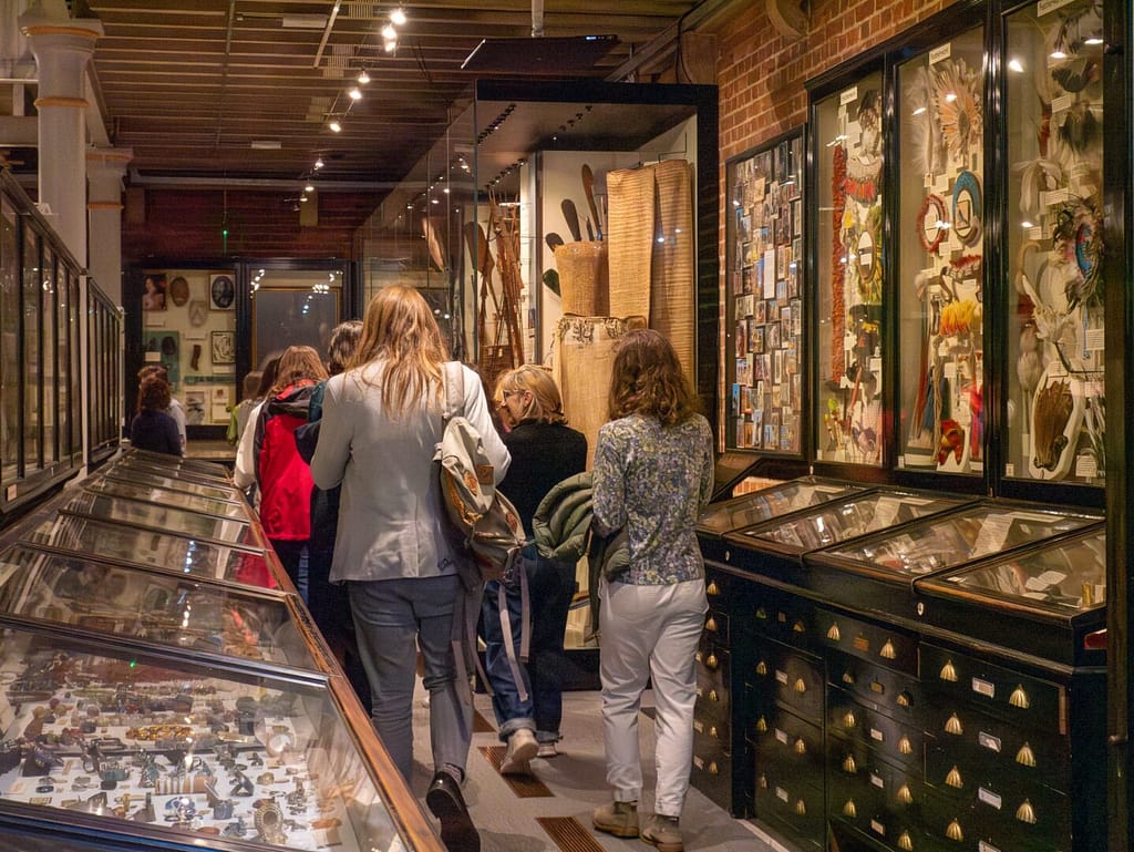 A group of attendees follow an Uncomfortable Oxford Tour guide around the Pitt Rivers Museum.