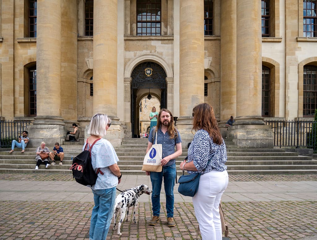 An Uncomfortable Oxford guide stands in front of the Clarendon building in central Oxford.