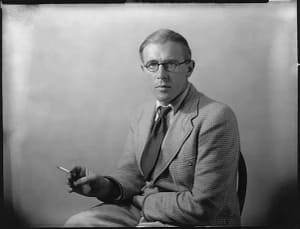 Black and white photo portrait of a man with glasses holding a cigarette: Minister of Housing and Local Government, Richard Crossman.