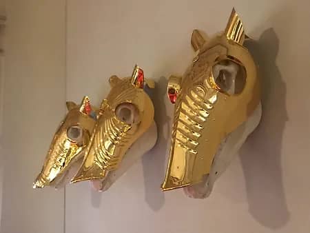 Three horse skulls adorned with solid gold helmets.
