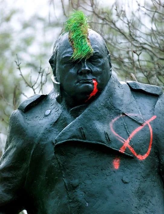 Picture of a statue altered with punk features such as green hair and red paint.