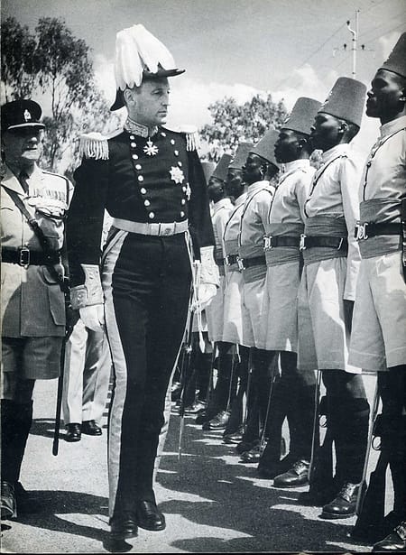 Evelyn Baring in an elaborate military uniform, surveying a line of soldiers.