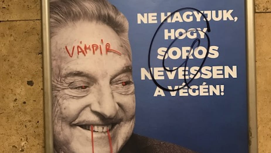 A poster of Hungarian politician George Soros is defaced with red paint making blood drip from his lips and saying 'Vampir' on his forehead.