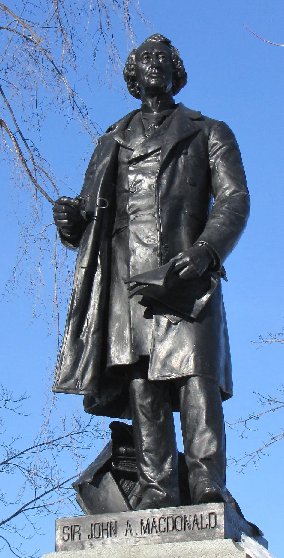 Picture of the statue of a man with a waistcoat and jacket.